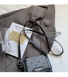 Détail d'un mini sac bandoulière vintage avec motif cœur et sangle ajustable