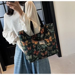 Detail of floral tote bag showing colorful butterfly embroidery and canvas texture