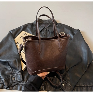 Detail of dark brown tote bag with vintage texture on leather jacket background