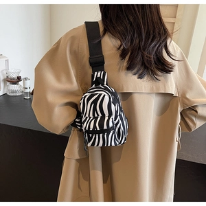 Close-up of zebra print mini backpack on model showing stylish black and white patterns