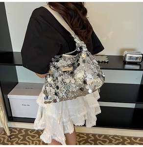 Silver sequin tote bag shown on model featuring mirrored sequins and a leather logo tag