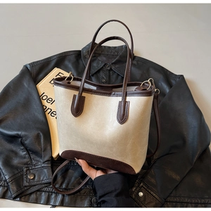 Detail of minimalist cream and brown tote bag with leather texture and shoulder strap