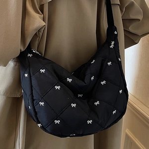 Black quilted crescent bag with white bow embroidery and wide shoulder strap