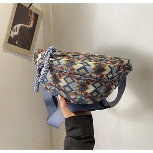 Close-up of geometric pattern crossbody chest bag with purple woven strap and charms
