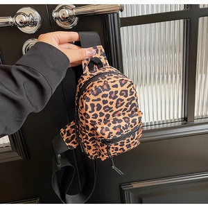 Close-up of leopard print crossbody bag featuring nylon texture and zipper compartments