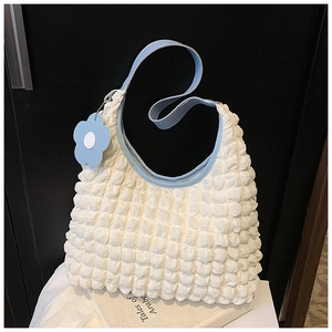 Vue détaillée du sac cabas gaufré blanc avec bandoulière bleu clair et breloque fleur