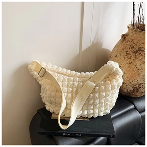 Detail of cream beige puff shoulder bag with bubble texture and adjustable fabric strap