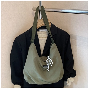 Dettaglio della borsa hobo in tela verde militare con etichetta e tracolla regolabile