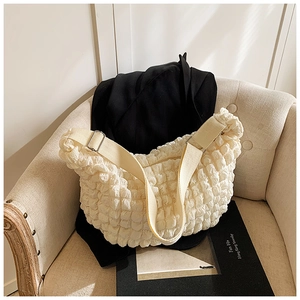 Detail of cream puff cloud shoulder bag featuring unique bubble pleated texture and strap