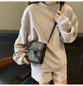 Détail du tissu à motif nœud gris et cuir noir sur un mini sac à bandoulière élégant