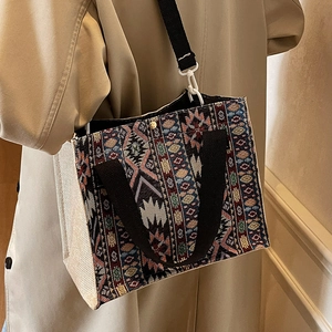Ethnic woven tote bag with geometric patterns and adjustable black shoulder strap