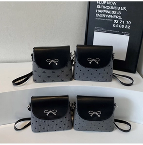 Détail de mini sacs seaux en toile avec boucles nœud argenté et motifs imprimés