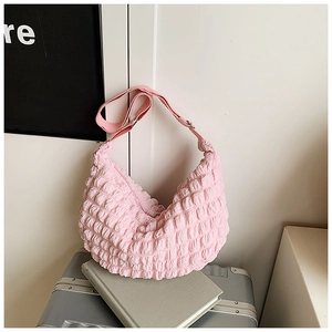 Detail of pink bubble texture fabric on a soft crossbody bag with adjustable strap