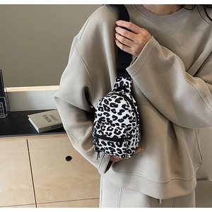 Detail of black and white leopard print chest bag with adjustable nylon strap and zippers
