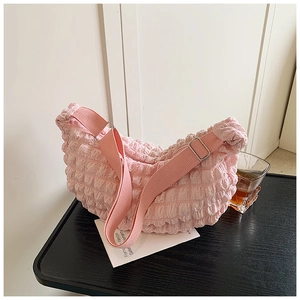 Close-up of pink bubble fabric crescent bag with pleated texture and silver buckle