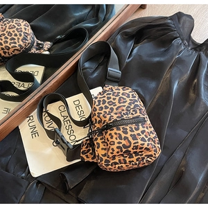 Detailed view of trendy leopard print crossbody bag with black adjustable strap and zippers