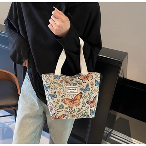 Macro detail of canvas tote bag featuring floral butterfly print and woven label