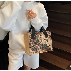 Detail of vintage floral jacquard tote bag with black handles and metal buckle