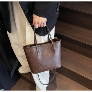 Detailed view of a brown vintage tote bag with pleated texture and leather straps