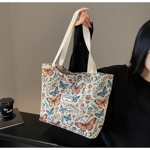 Detailed close-up of vintage floral canvas tote bag showing textured butterfly patterns