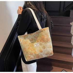 Close-up of jacquard sunflower tote bag featuring thick handles and branded woven label