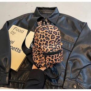 Detail of leopard print chest bag with black adjustable strap and metal zipper
