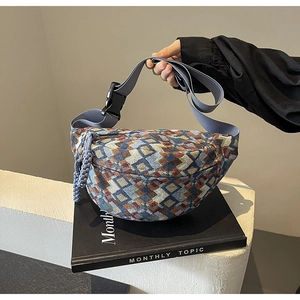Close-up of geometric jacquard chest bag with blue strap and plastic buckle detail