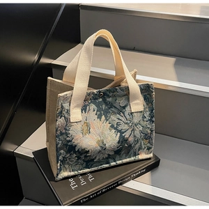 Detail of floral jacquard tote bag with reinforced handles and secure snap closure