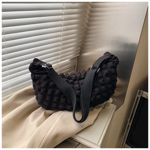 Detailed close-up of a black popcorn-textured hobo bag with adjustable wide strap