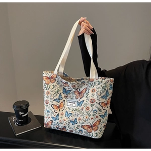 Close-up of floral print tote bag with butterfly patterns and sturdy canvas handles