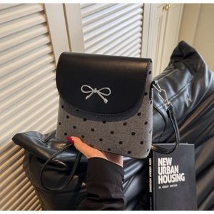 Détail du sac en laine grise à pois noirs et fermoir en métal argenté en nœud