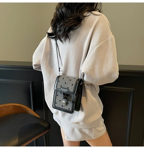 Détail du mini sac à bandoulière gris à pois avec broderie de nœuds délicats