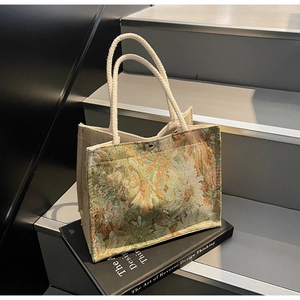Detail of floral jacquard embroidery tote bag with cotton rope handles on art books