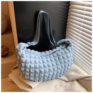 Close-up of light blue bubble textured fabric and adjustable strap buckle on tote bag