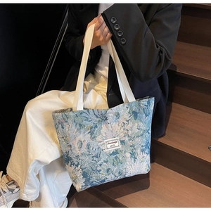 Detail of vintage floral jacquard tote bag with woven handles and decorative fabric label