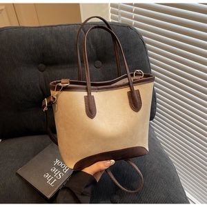 Detail of beige and brown leather tote bag showing lychee grain texture and stitching