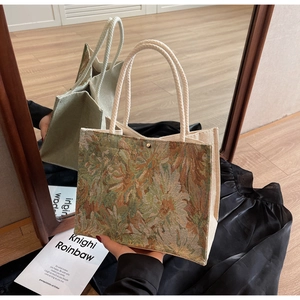 Detail of floral jacquard embroidery tote bag with woven cotton rope handles and magnetic snap