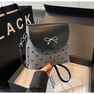 Close-up of leather bow buckle and grey polka dot felt on a luxury bucket bag