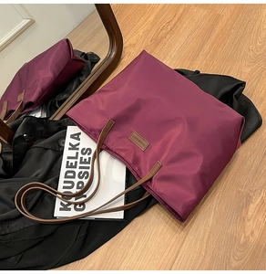 Close-up of burgundy nylon tote bag with leather straps and Fashion & Bags leather logo