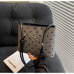 Detailed macro view of grey polka dot canvas bag with silver bow buckle and knotted strap