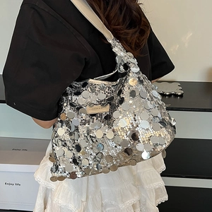 Chic silver sequin tote bag with leather strap shown in a stylish shoulder carry pose