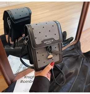 Vue détaillée du mini sac téléphone avec imprimé cœur gris et logo métallique