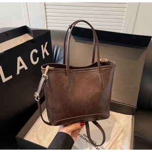 Detail view of dark brown tote bag with retro leather texture and Senya Bags logo