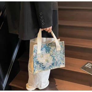 Detail of floral embroidery on a vintage style tote bag with sturdy cotton handles