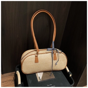 Detail of woven beige shoulder bag with brown leather handle and blue plaid ribbon accent