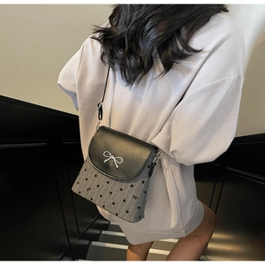 Détail du sac seau gris à pois avec élégant nœud argenté et rabat en cuir de qualité