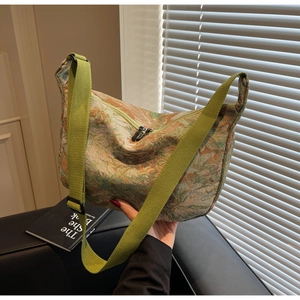 Detail of green floral jacquard fabric tote with wide shoulder strap and metal zipper