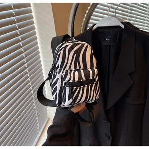 Detailed close-up of a mini zebra print backpack with black and white animal pattern texture