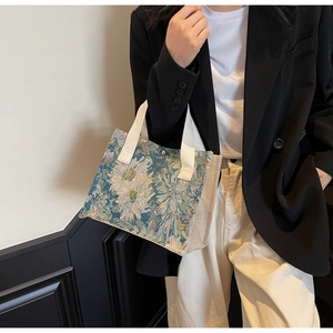 Floral embroidery detail on cotton linen tote bag with cream canvas side panels