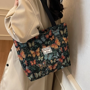 Vintage floral tote bag with butterfly jacquard pattern shown on a model side shoulder